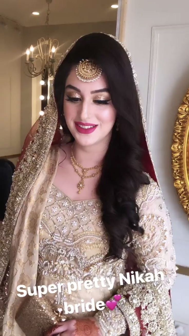 a woman wearing a bridal outfit and smiling for the camera