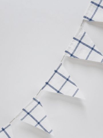 three pieces of white and blue fabric hanging on a wall