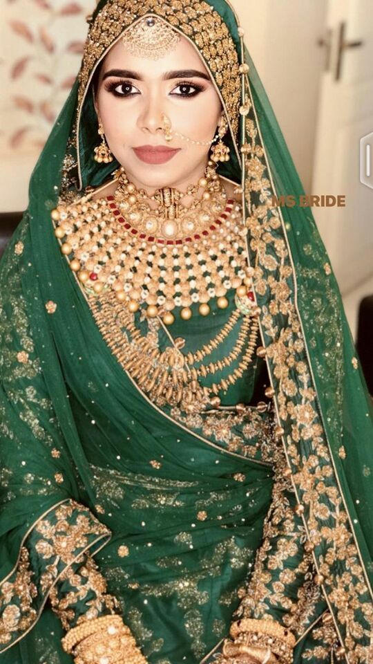 a woman in a green and gold bridal outfit