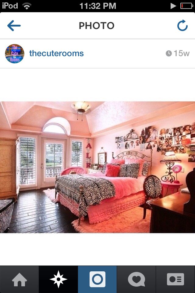 a bedroom decorated in pink and black with pictures on the wall above the bed, along with two desks