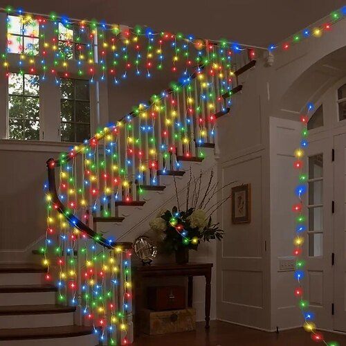 a staircase decorated with multicolored christmas lights