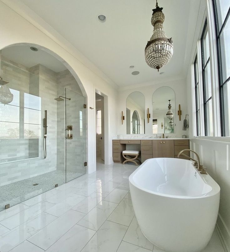 a large white bath tub sitting in a bathroom next to a walk - in shower