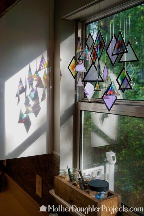 the sun shines through stained glass windows in a kitchen area with wooden cabinets and drawers