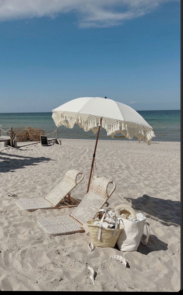 an umbrella and some chairs on the beach