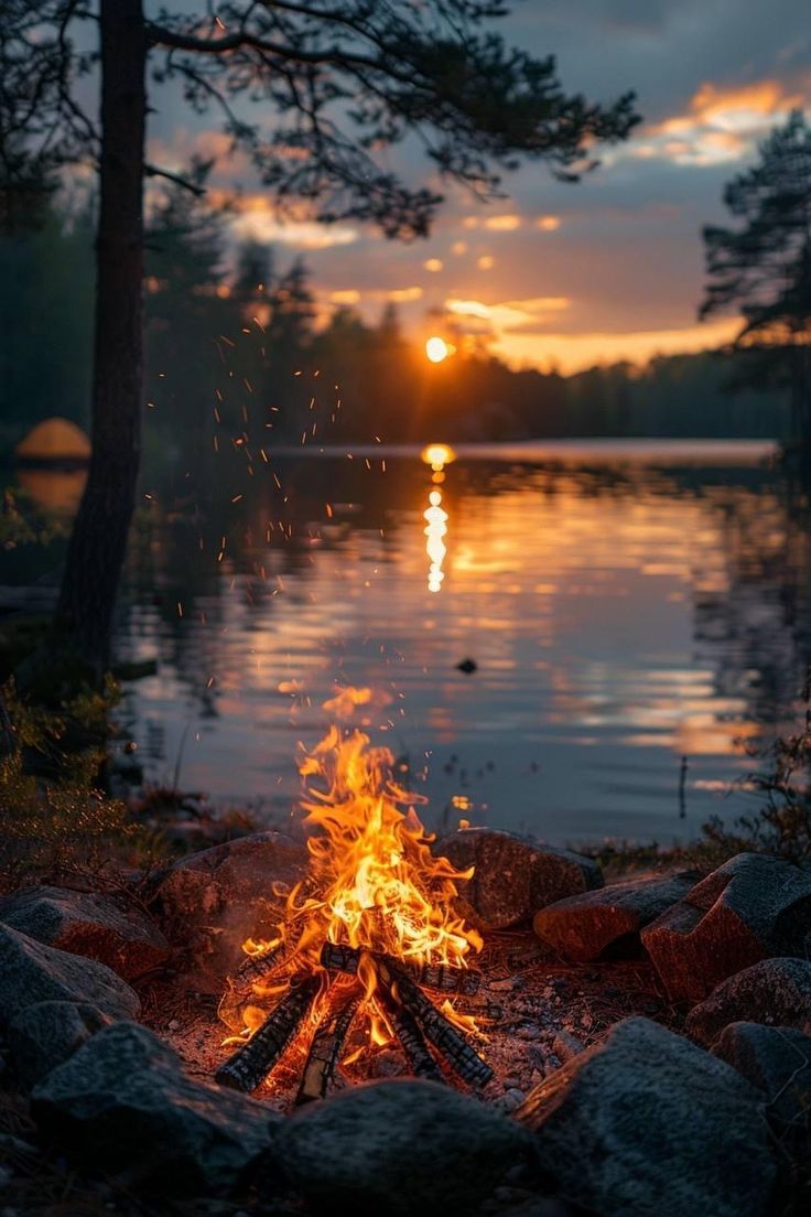 a campfire with the sun setting in the background