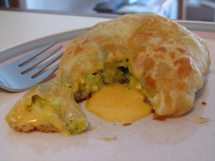 an egg and broccoli pastry on a plate with a fork