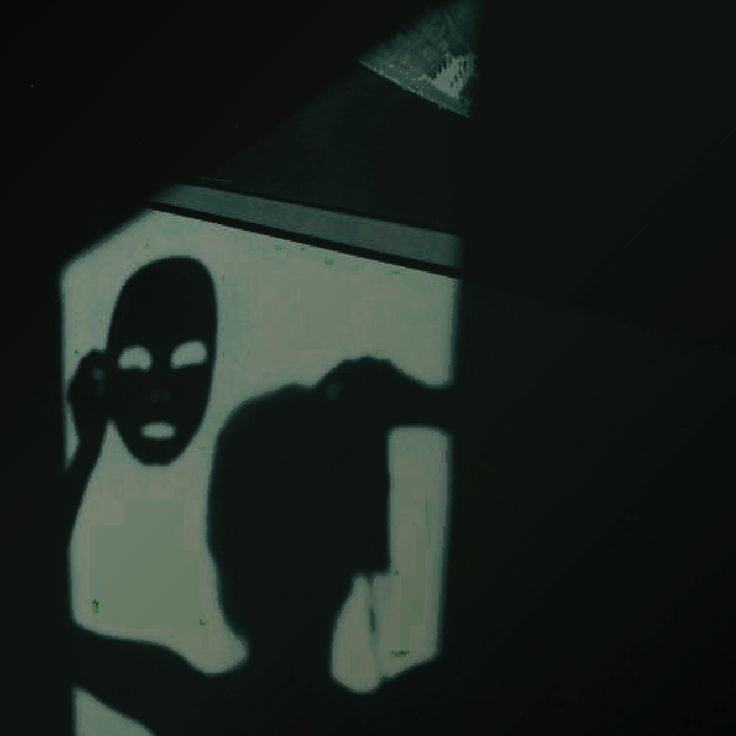 the shadow of a person with a mask on