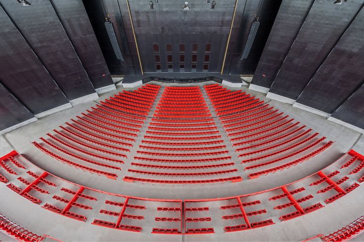 an empty auditorium with rows of red seats