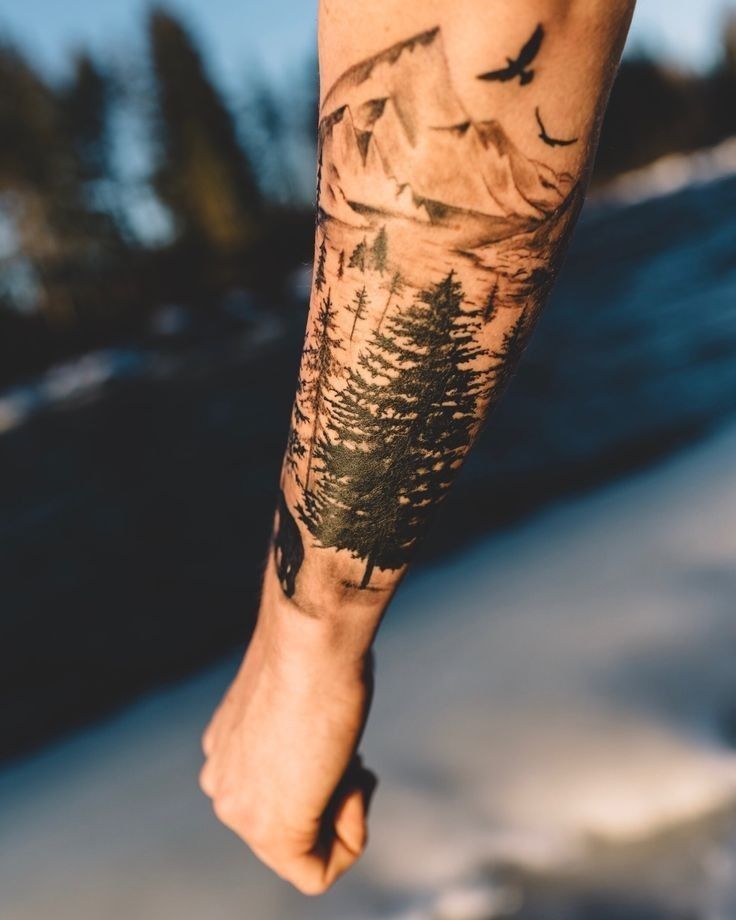 a person with a tattoo on their arm holding a skateboard in front of snow covered ground