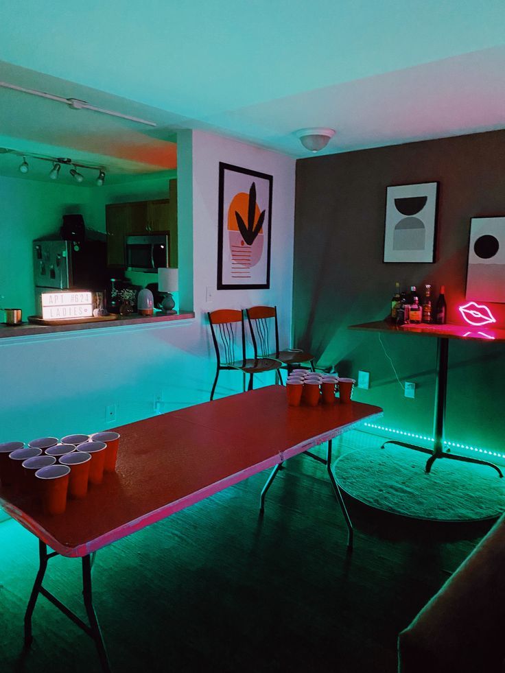 a long table with cups on it in the middle of a room filled with lights