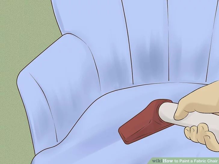 a person using a paint roller to clean a blue chair with the seat upholstered