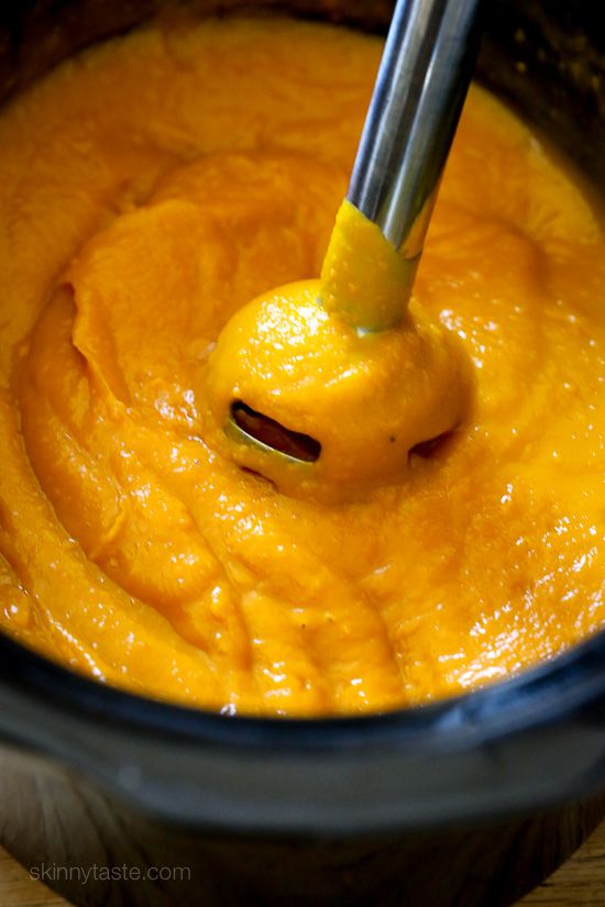 an orange sauce in a pot with a ladle scooping it into the bowl