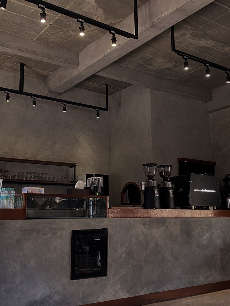 a coffee shop with lots of counter space and lights on the ceiling above it's counters