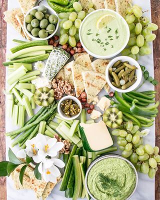 a table topped with lots of different foods and dips on top of each other