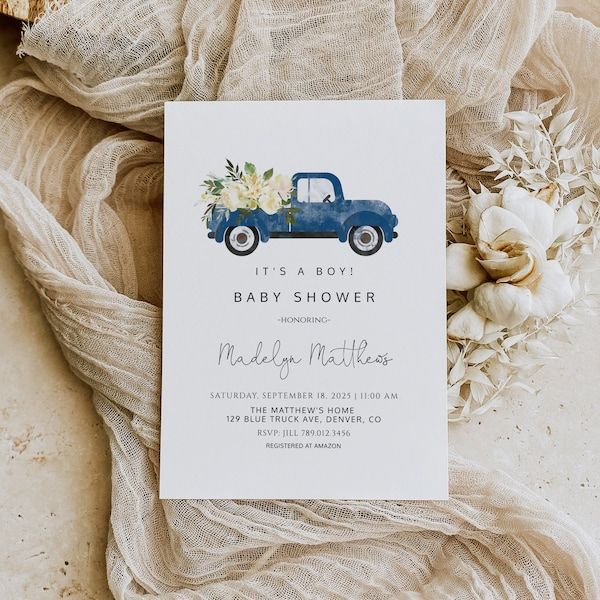 a baby shower with a blue truck and flowers on the front, sitting next to some burlap