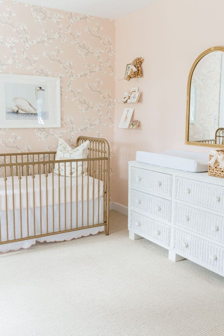 a baby's room with a crib, dresser and mirror