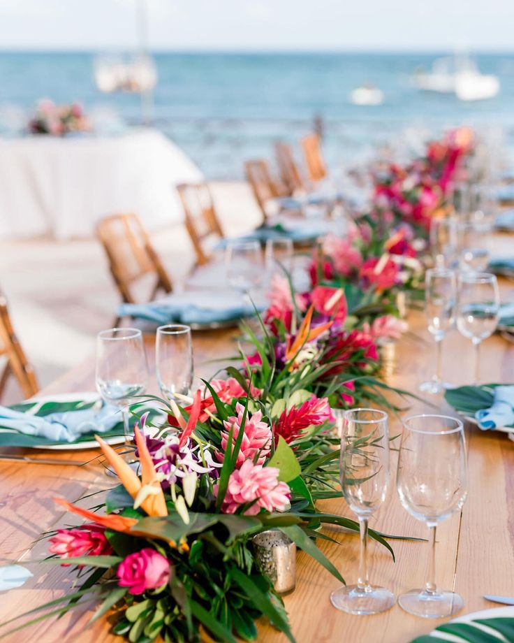 a long table set up with flowers and wine glasses