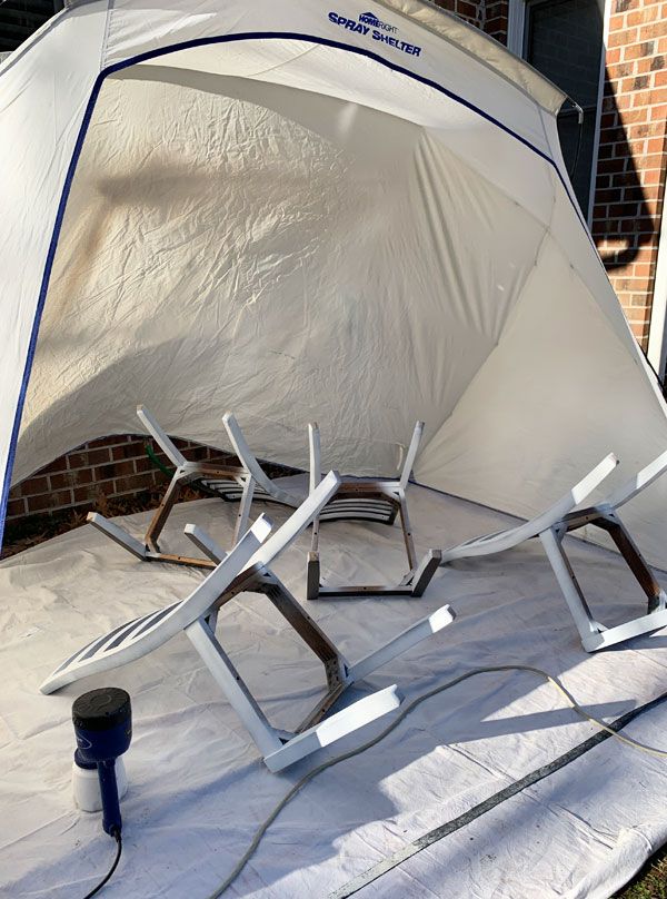 a white tent with chairs sitting on top of it next to a brick building in the background