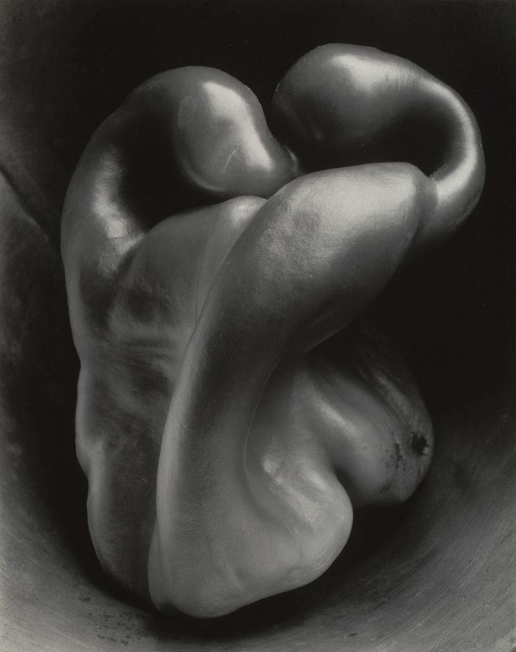 a black and white photo of peppers in a bowl