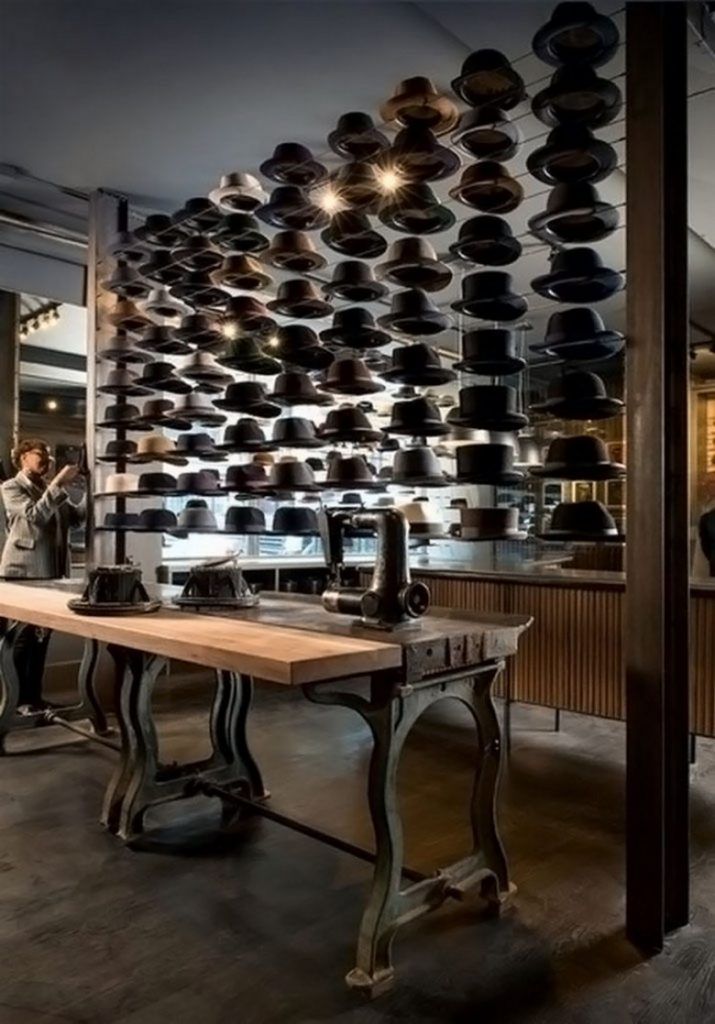 a room filled with lots of pots and pans hanging from the ceiling next to a wooden table