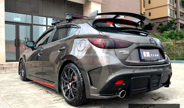 the rear end of a gray car parked in front of a building