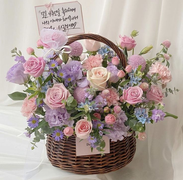 a basket filled with lots of pink and purple flowers