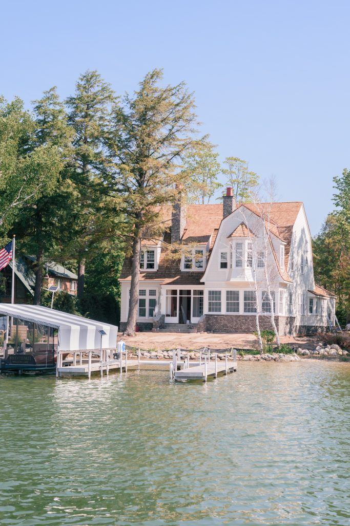 a large white house sitting on top of a lake