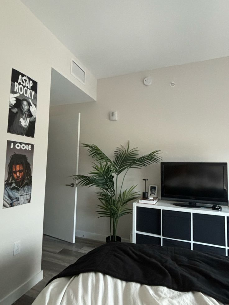 a bed room with a neatly made bed and a flat screen tv on the wall