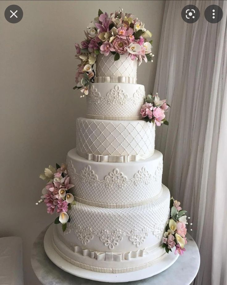 a large white wedding cake with flowers on top