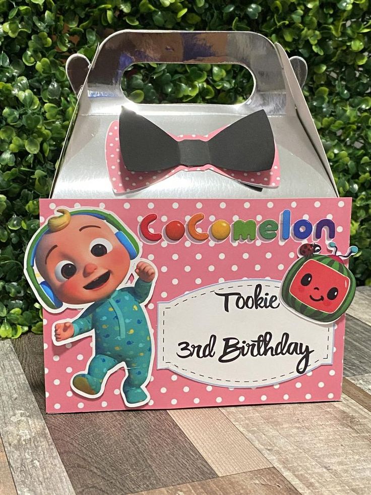 a pink box with an image of a cartoon character on it and a black bow tie