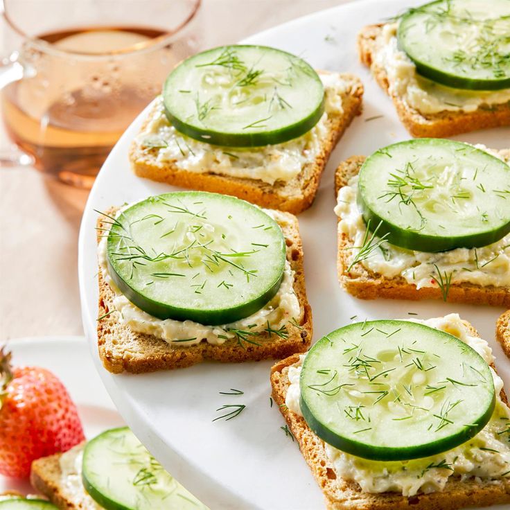 cucumber and cheese sandwiches are arranged on a plate