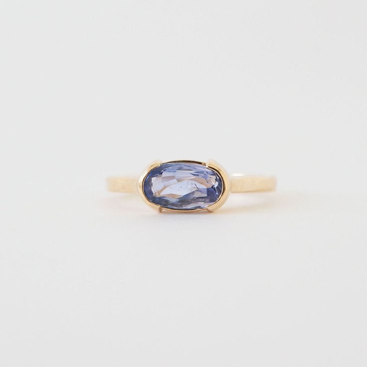 A modern and unexpected departure from the typical engagement ring, the Avery Ring features a stunning East West set blue sapphire. The half-bezel setting makes the stone to really pop, showing off its stunning purple-blue hue. Details 1.58ct Ceylon Blue Sapphire: 9.70x5.40mm 14K yellow gold weighing 4.26 grams Current size: 8 with complementary resize Band width: 2.15mm Half bezel set center stone Low set: looks great with Cleo, Jamie (second photo), and Thea Bands One of a kind center stone Sh Blue Enamel Ring, Bezel Sapphire Ring, East West Sapphire Ring, Bezel Set Sapphire Ring, Blue Moissanite Engagement Ring, Bezel Sapphire Engagement Ring, Unique Gemstone Rings, East West Half Bezel, Sapphire Bezel Ring