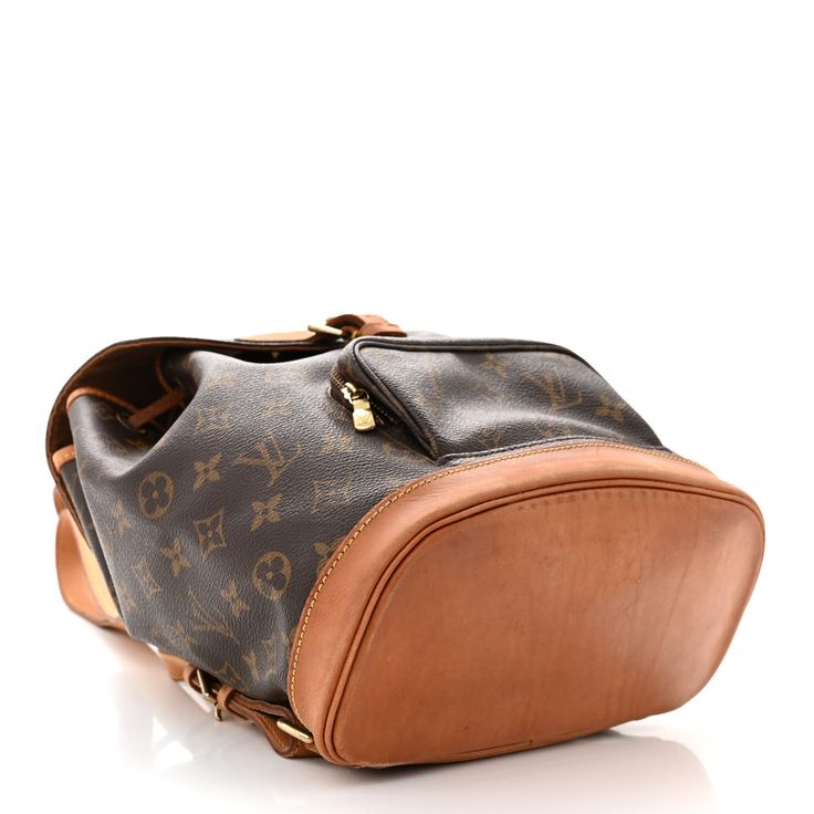 This is the authentic LOUIS VUITTON Monogram Montsouris MM Backpack. This backpack is crafted of monogram coated canvas with vachetta trim including shoulder straps, base, and a cinch cord. The bag also features brass hardware, an exterior zipper pocket and a flap with a belt closure. The top opens to a cocoa brown fabric interior with a patch pocket and a D ring. Cocoa Brown, Brown Fabric, Brass Hardware, Authentic Louis Vuitton, Louis Vuitton Monogram, Patch Pocket, Shoulder Straps, Zipper Pocket, Cocoa