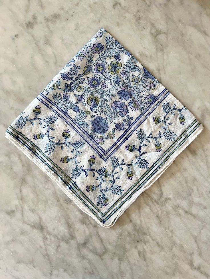 a blue and white floral design napkin on a marble surface