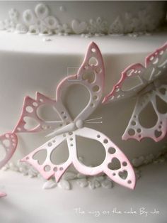 a white cake with pink and white butterflies on it