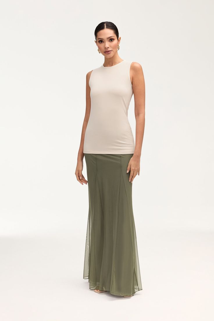 Indulge in elegance with our Milia Mesh Maxi Skirt in Smokey Olive. This skirt features intricate princess seam detailing and godets, making it a luxurious statement piece. The mesh material adds a touch of allure, making it perfect for any upscale event. Model is 5'7" and is wearing size S/44". Please note this garment runs tight. We kindly recommend choosing one size up from your usual size.