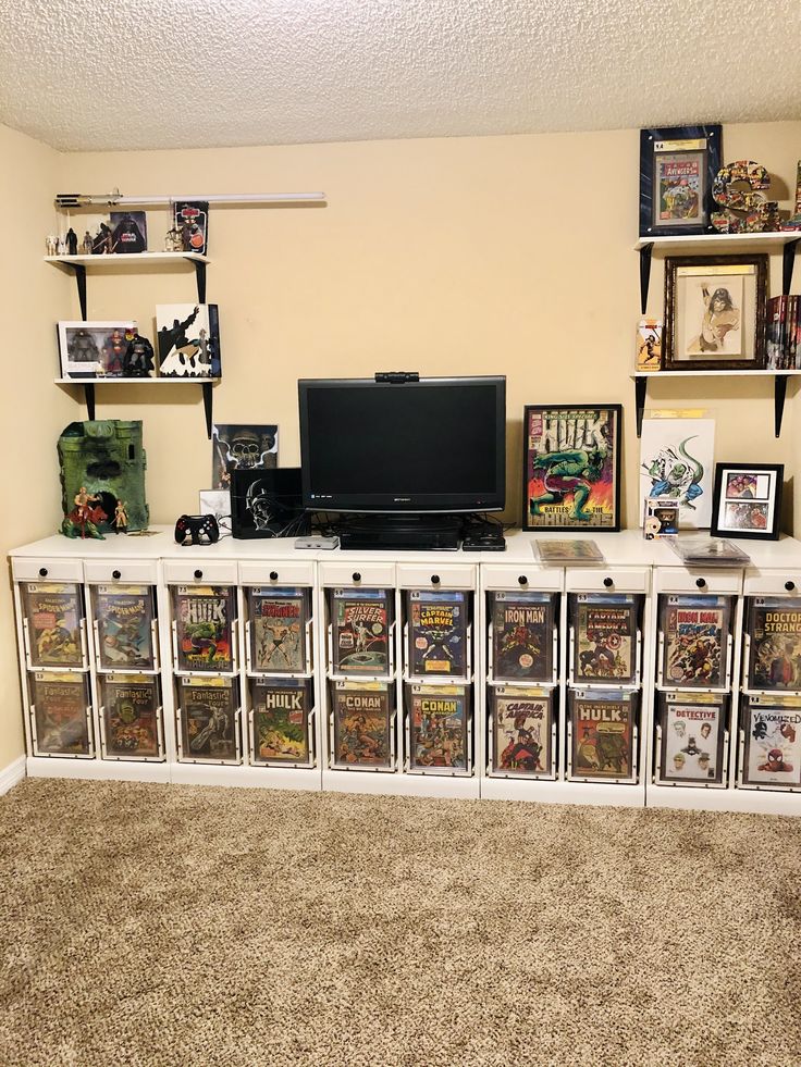 a television sitting on top of a white entertainment center filled with comic books and dvds