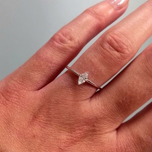 a woman's hand with a diamond ring on it