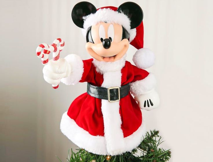 a mickey mouse ornament on top of a christmas tree with candy canes