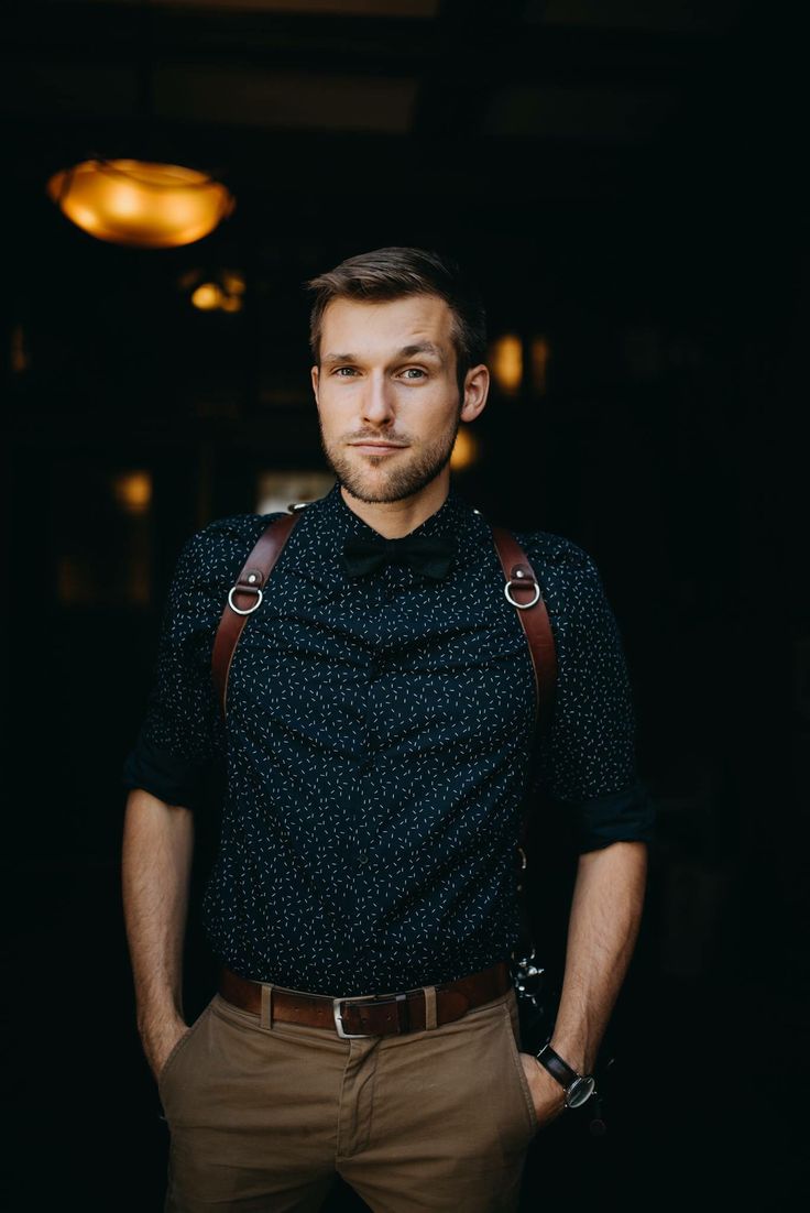 a man wearing suspenders and a black shirt