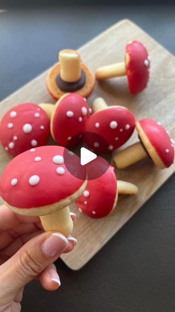 a person holding a piece of food with mushrooms on it and the image is made out of fondant