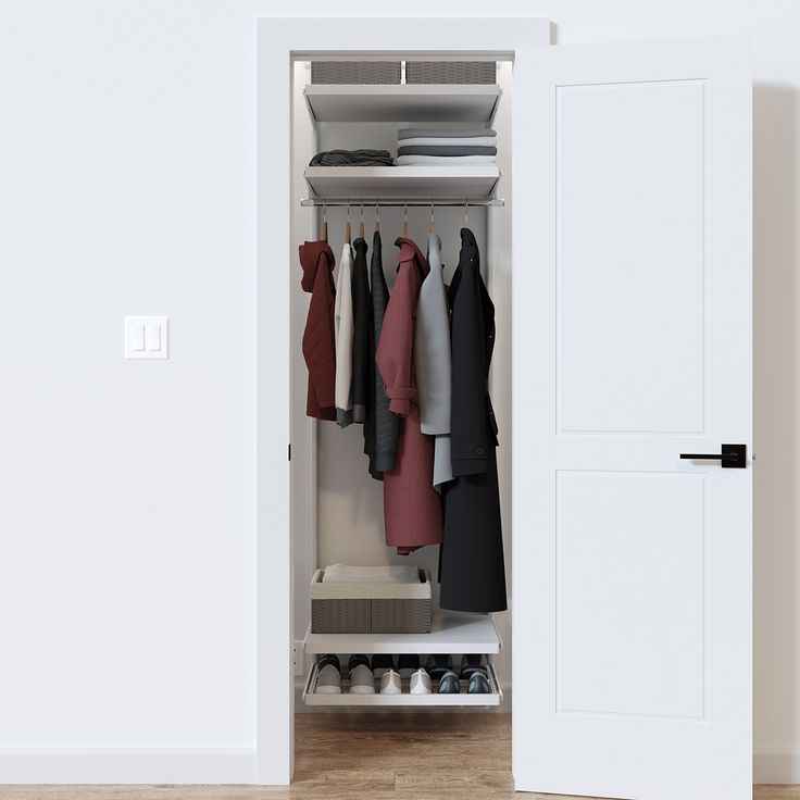 an open closet with clothes on hangers and shoes in the bottom drawer, next to a white door