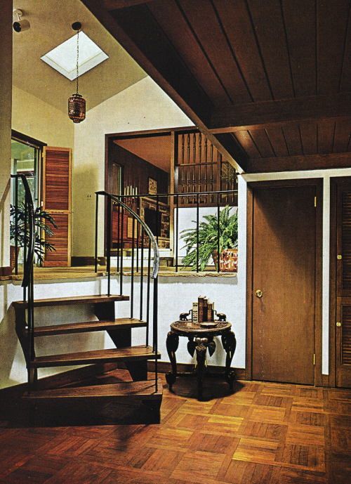 an entry way with stairs and a table on the floor in front of a window