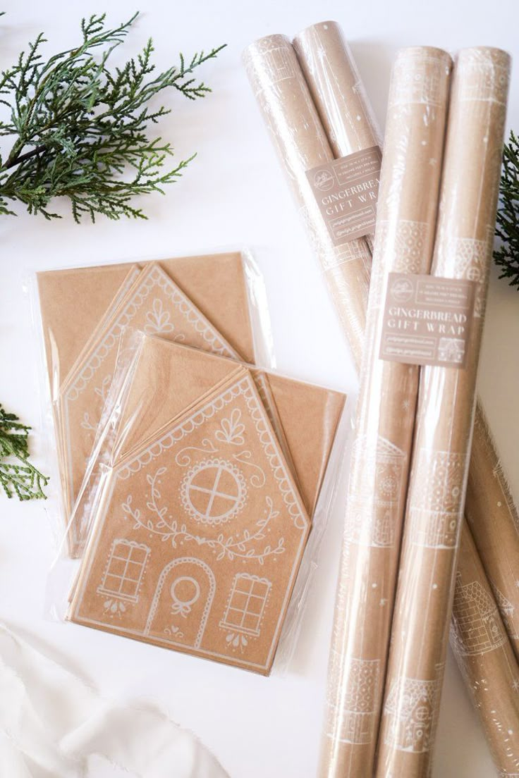 some brown wrapping paper sitting on top of a white table next to christmas decorations and greenery