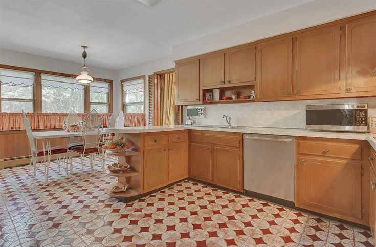 a kitchen with wooden cabinets and tile flooring