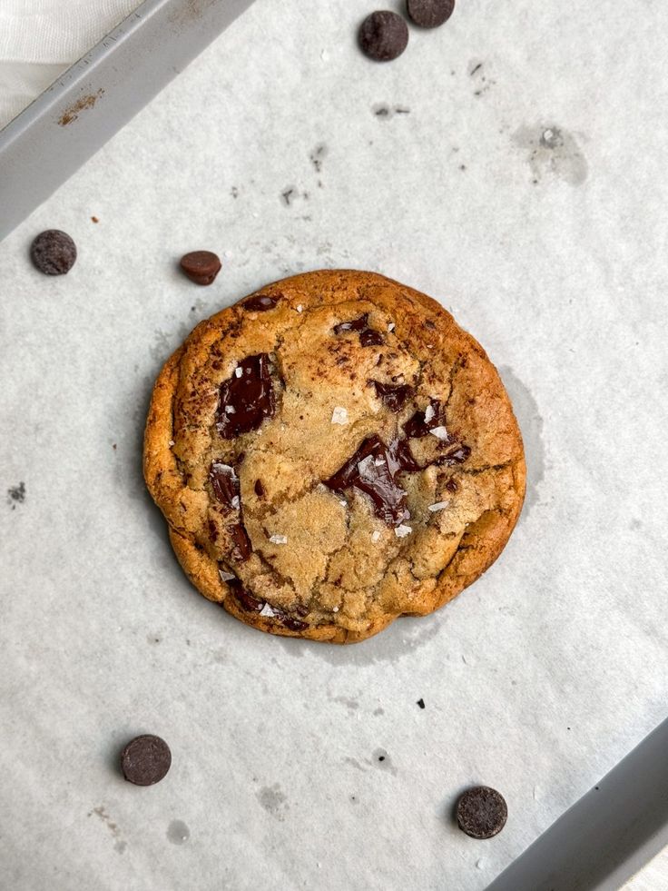 a chocolate chip cookie sitting on top of a pan