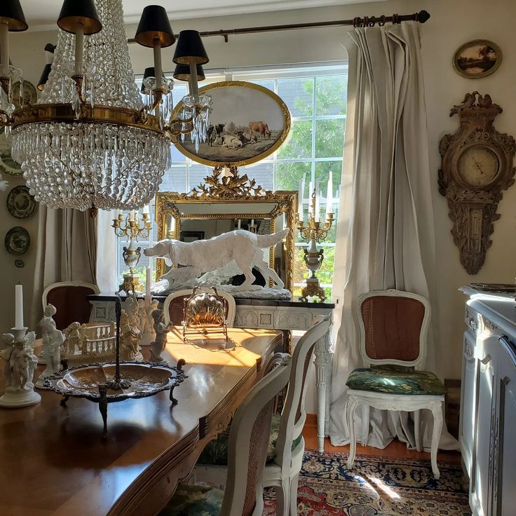 a dining room table with chairs and chandelier hanging from it's ceiling