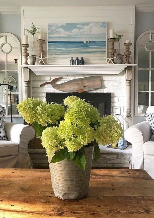 a living room filled with furniture and a fire place covered in green hydrangeas