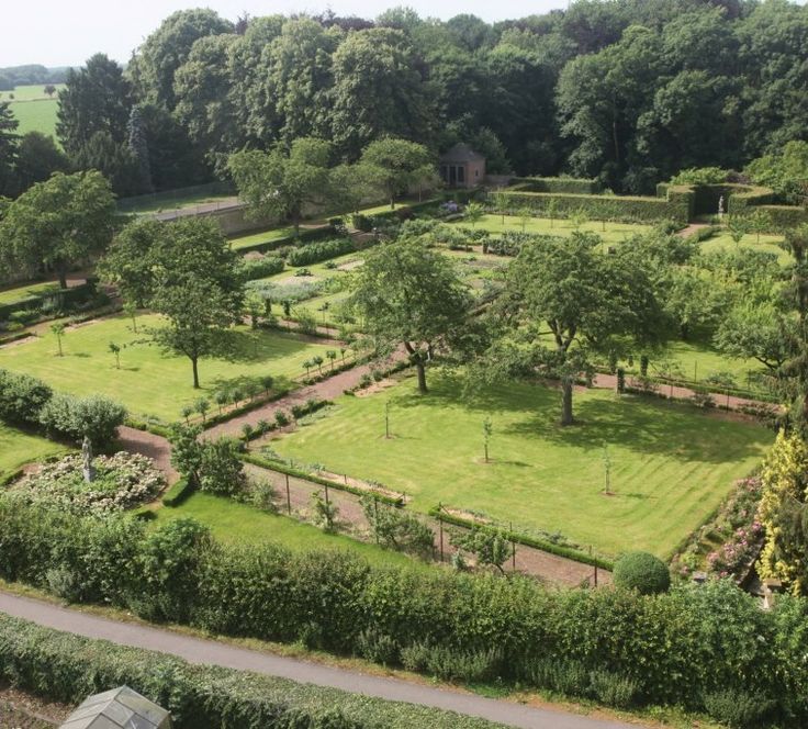 an aerial view of a lush green park with trees and bushes in the foreground