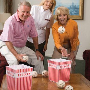 three people standing around a table with popcorn boxes on it